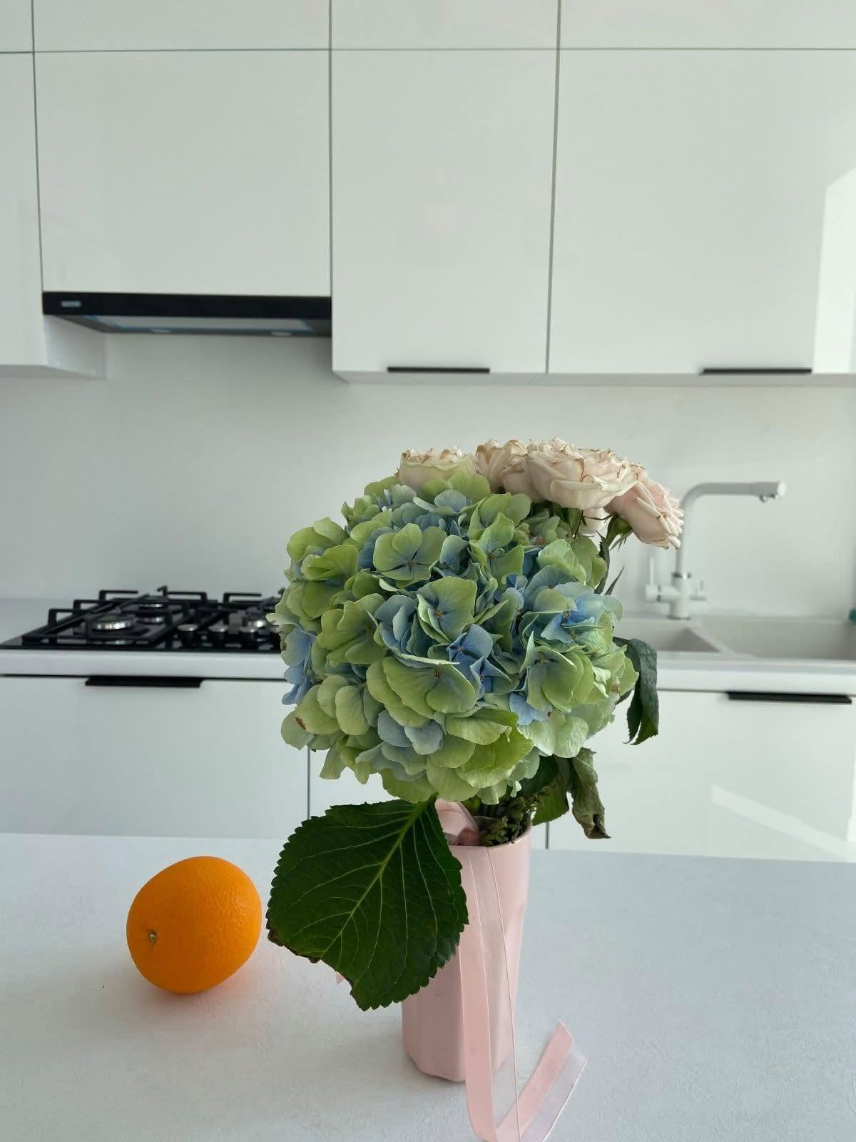 Rent vitt kök med blombukett på bänken